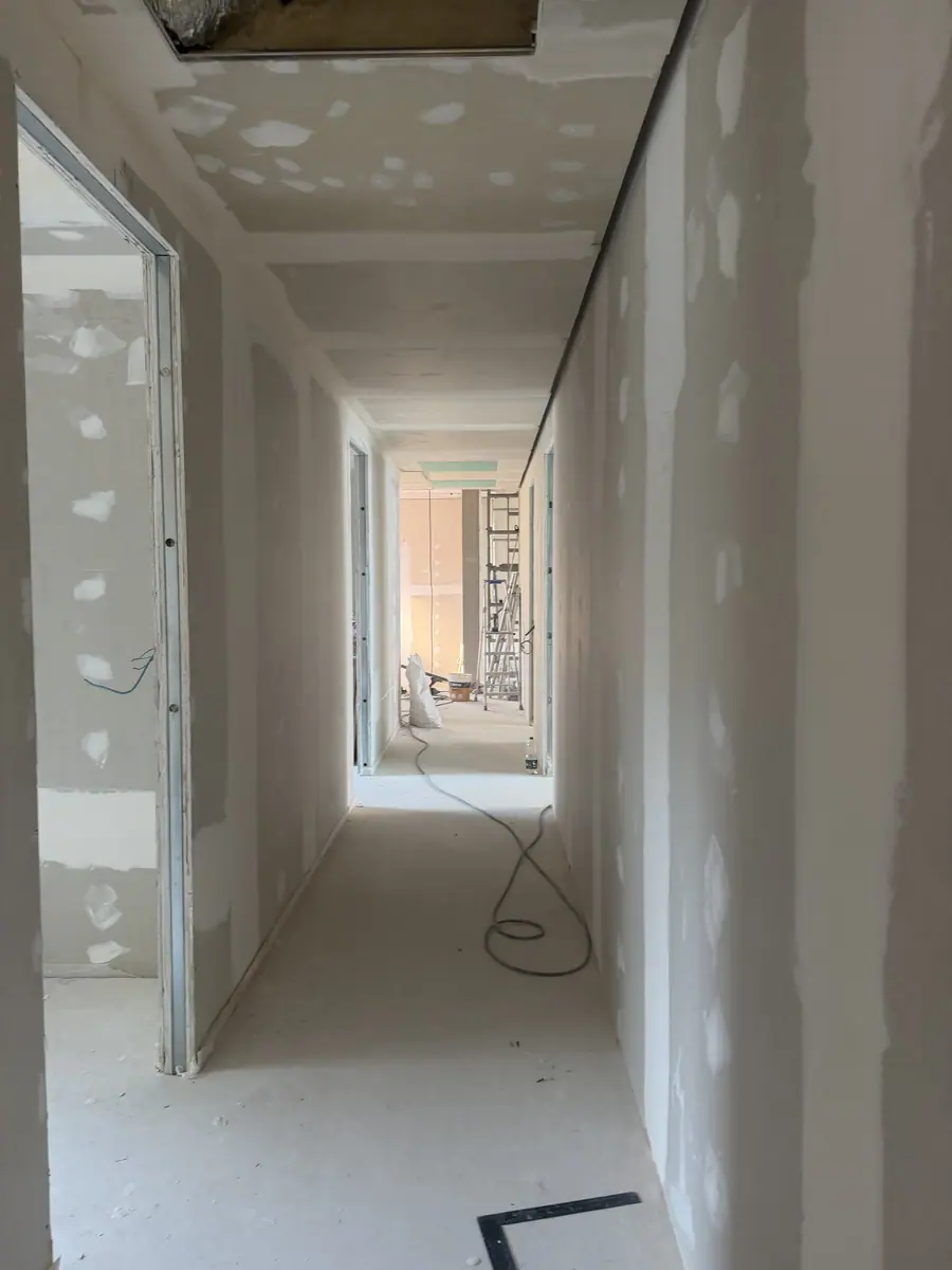 Corridor partitioned in plasterboard with joints taped, at second-fix stage