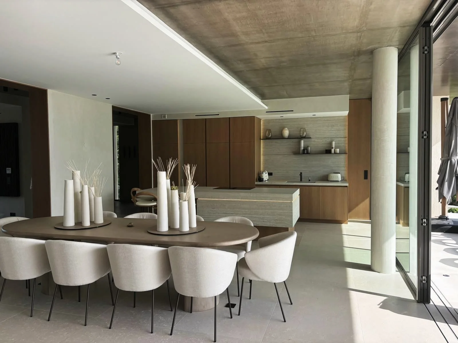 Open-plan kitchen in oak and travertine