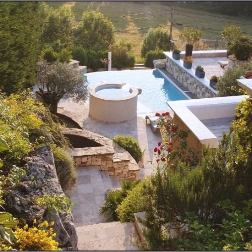 Pool and hot tub set in stone terraces
