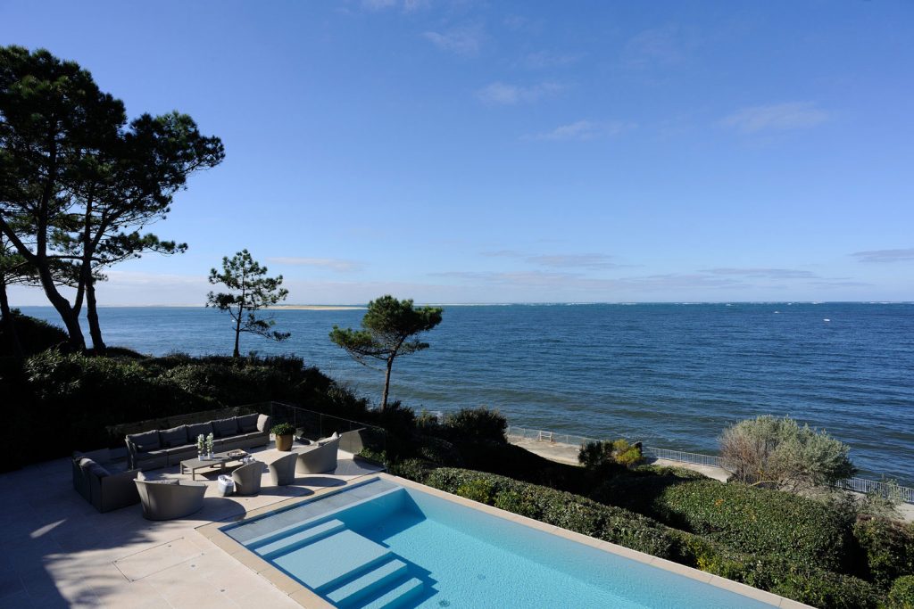 Vue sur la mer depuis la terrasse en pierre avec piscine donnant sur le paysage avec Infinity Partners 