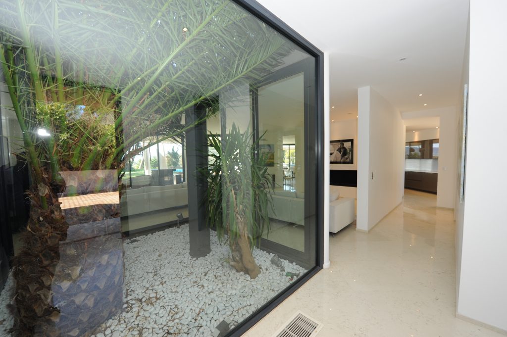vue d'un espace d'entrée avec puit de lumière vitré espaces en béton moderne blanc, de propriété avec Infinity Partners 