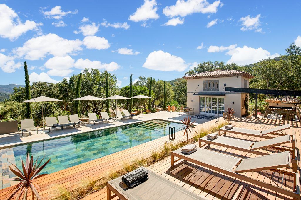 résultat d'une rénovation avec terrasse en bois avec transats de luxe et vue sur piscine avec Infinity Partners 